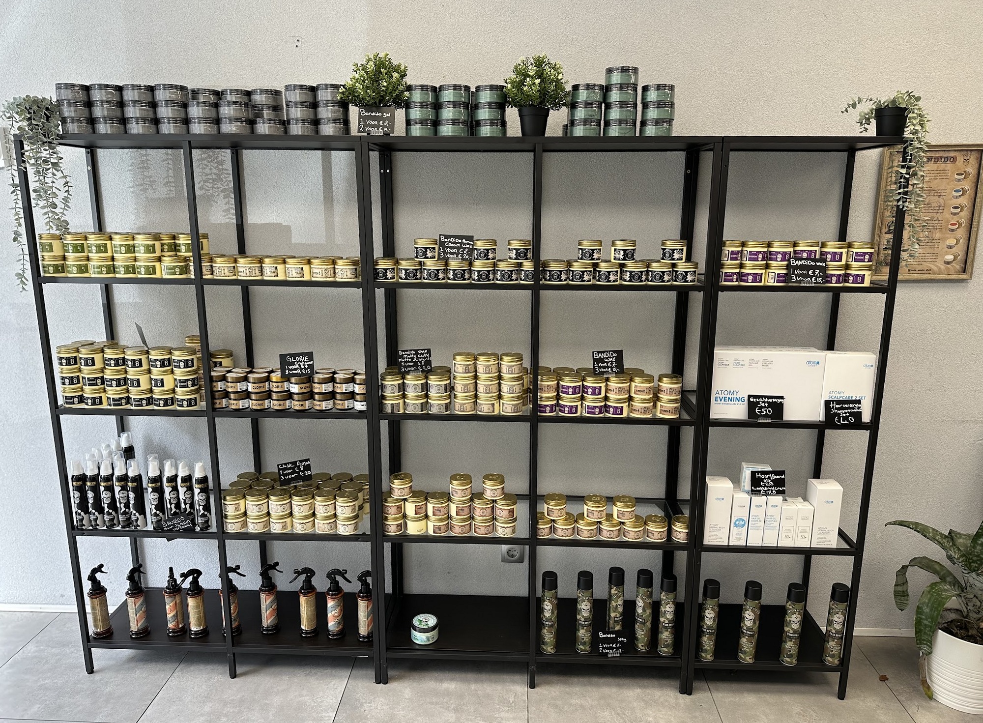 Een zwarte stellingkast met rijen potjes pomade en flessen haarproducten